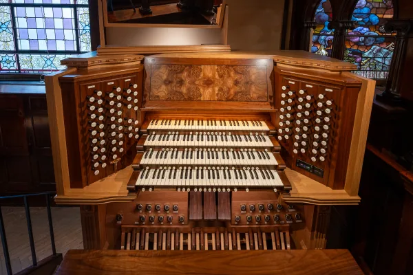 Front view of the Bicentennial Pipe Organ console showing its four keyboards and banks of ivory stop knobs