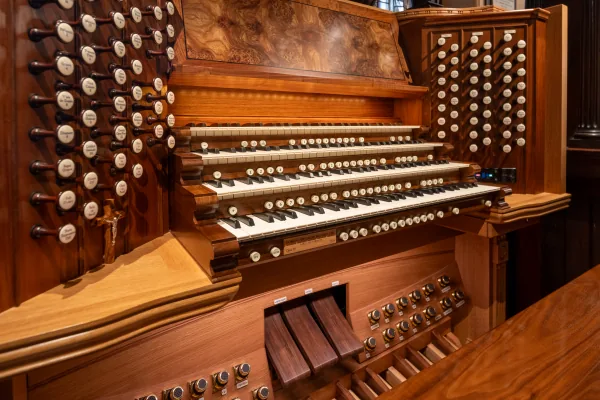 Angled view of the Bicentennial Pipe Organ console, its stop jambs and pedalboard in polished timber
