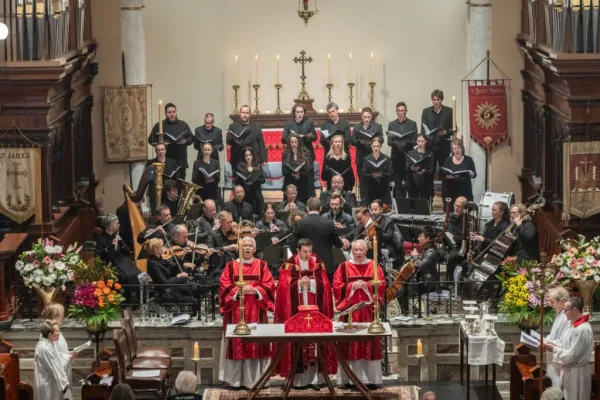 Choir, orchestra and clergy in red vestments during the Candlemas Orchestral Mass at St James' Church
