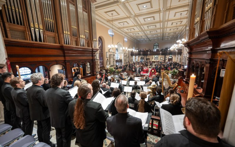 The choir and orchestra performing beneath the organ pipes in the nave of St James' Church