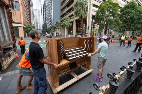 Organ builders wheeling the Bicentennial Pipe Organ console along a Sydney street towards St James' Church
