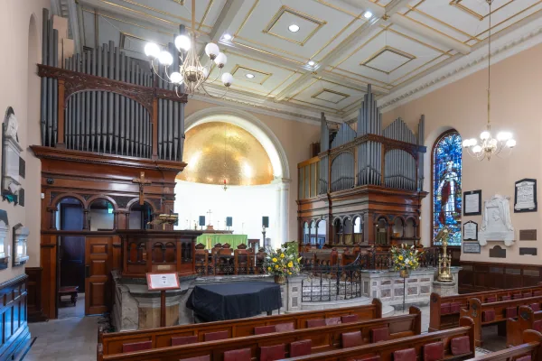The previous pipe organ at St James' Church, its timber case and pipes seen across the nave